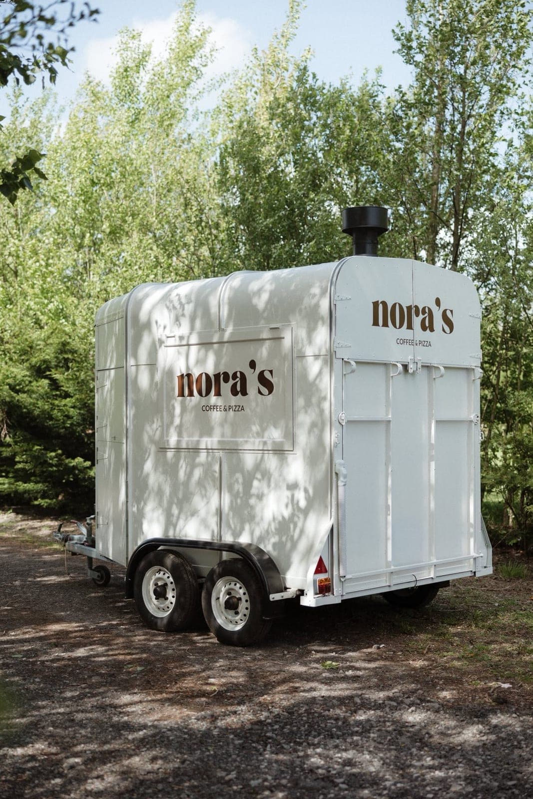 Side view of Nora’s pizza trailer with its oven chimney