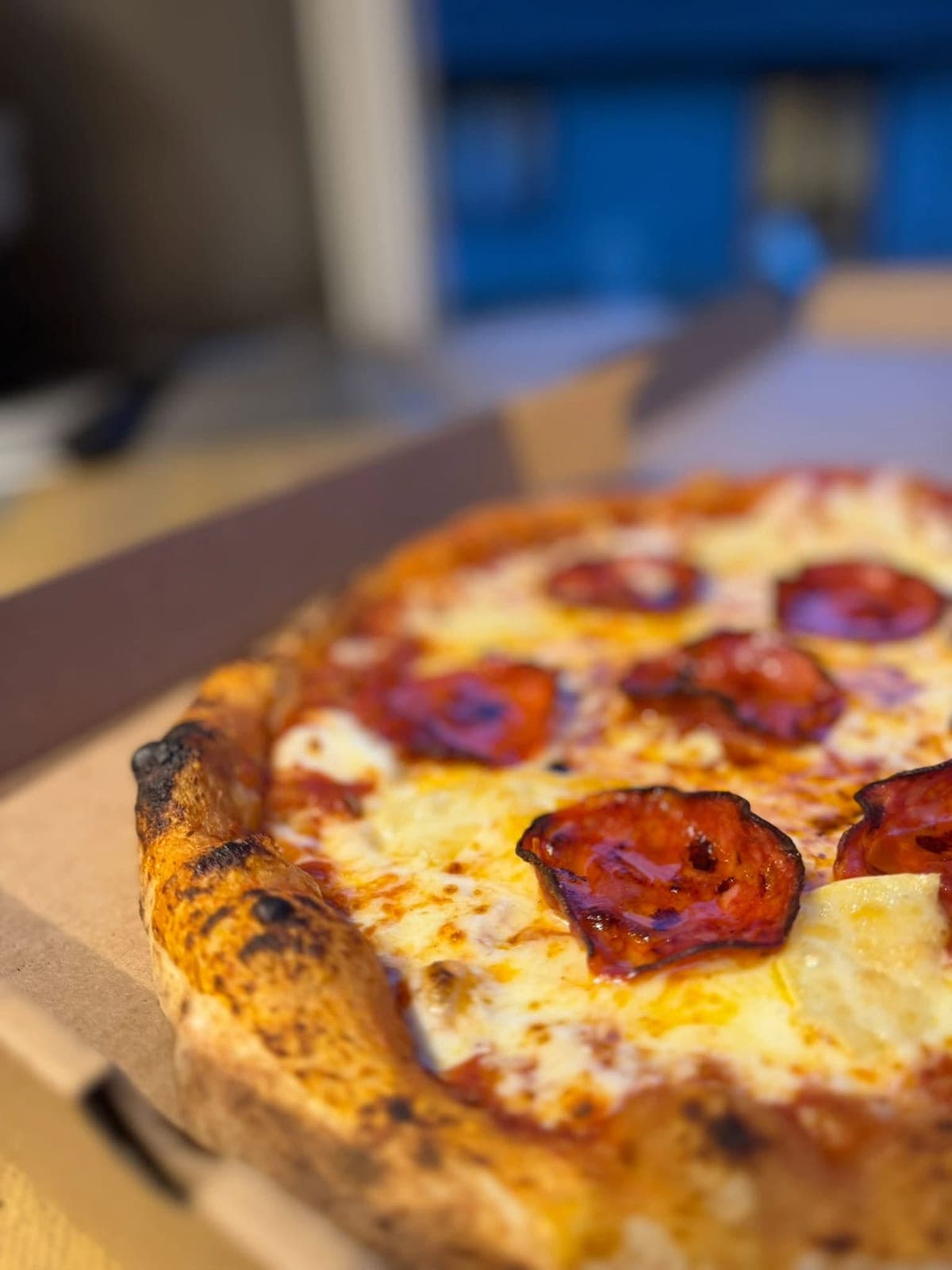 Close-up of a blistered sourdough crust with pepperoni